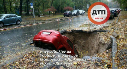 В Киеве водитель отказывается забирать провалившийся в яму автомобиль