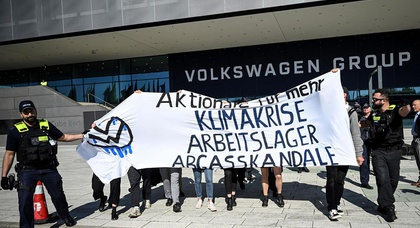 Cake-throwing activists disrupt Volkswagen's annual meeting in Berlin, protesting the automaker's environmental past and alleged links to forced labor at its Chinese plant