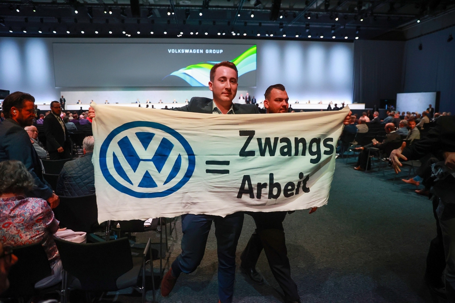 A protester with a banner reading “VW = Forced Labor” at the Volkswagen AGM in Berlin, on May 10.Photographer: Krisztian Bocsi/Bloomberg