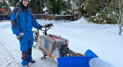 Un homme transforme un vélo en chasse-neige et dégage des chemins pendant les tempêtes hivernales