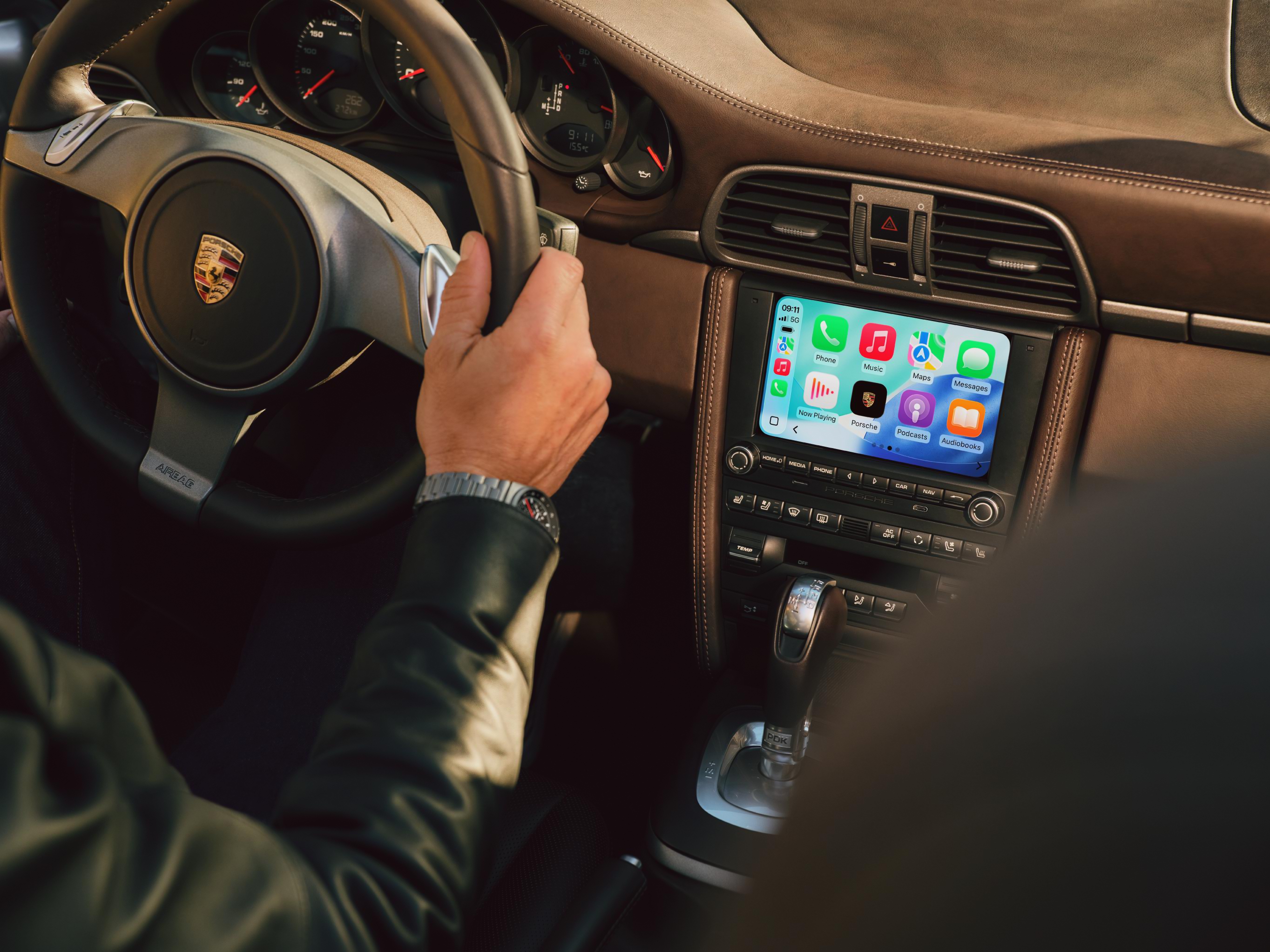 Экран PCCM Plus с CarPlay на руле с логотипом Porsche